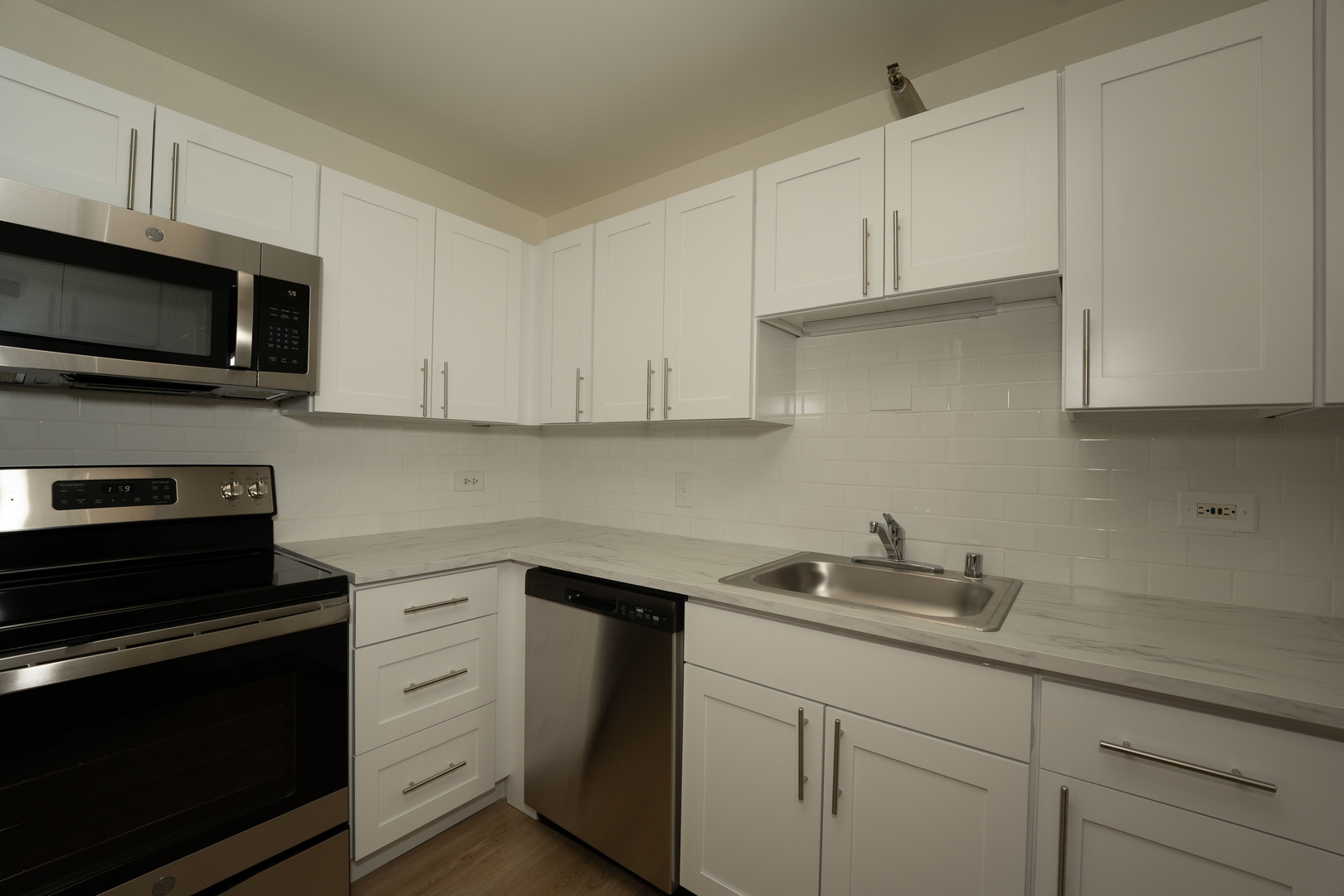 1111 North Dearborn Street, Unit 702 Chicago, IL 60610 - Photo 2 of 7 a kitchen with stainless steel appliances granite countertop white cabinets and a stove a oven with white countertops