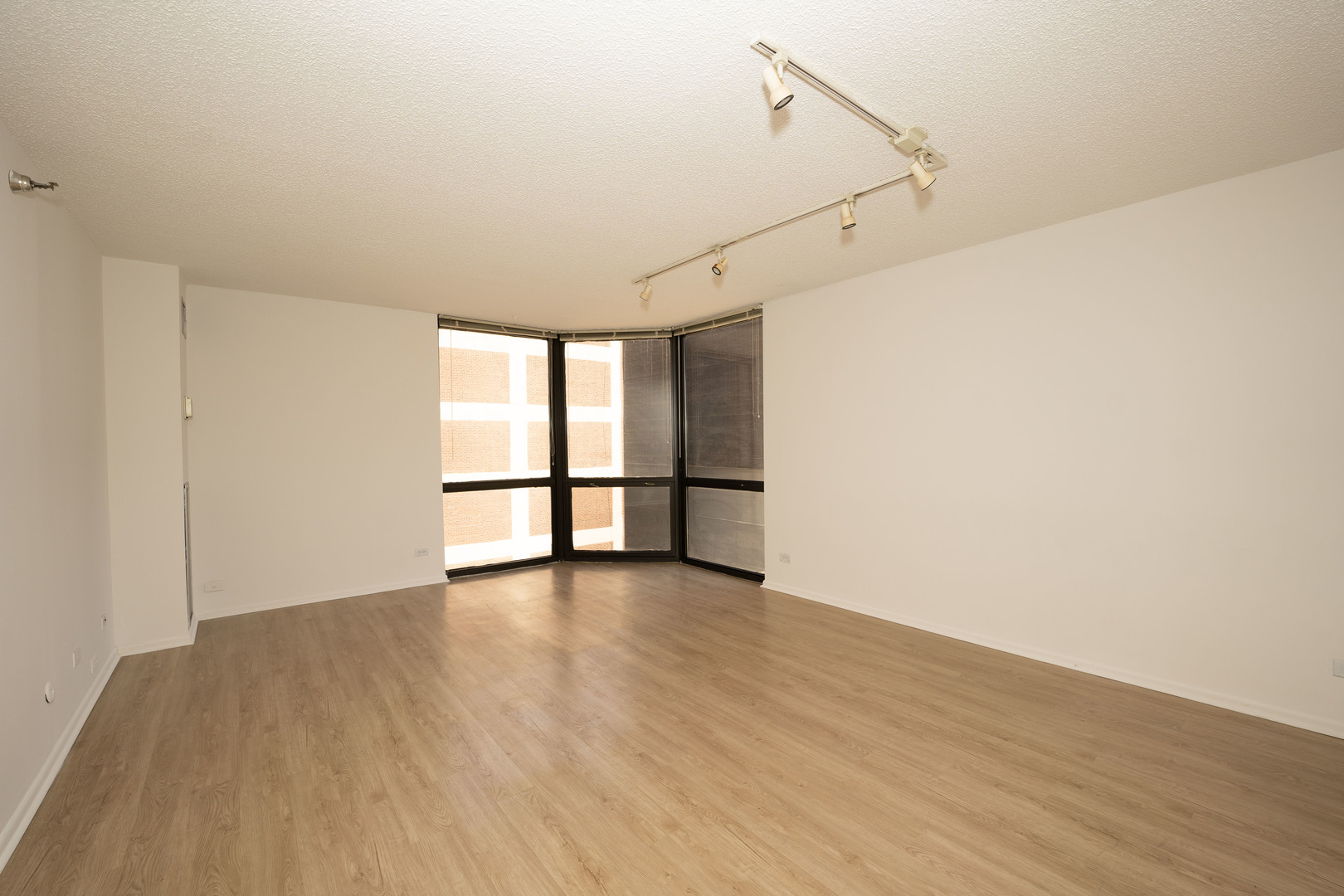 1111 North Dearborn Street, Unit 702 Chicago, IL 60610 - Photo 4 of 7 a view of an empty room with wooden floor and a window