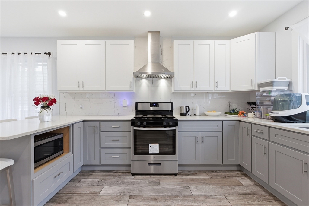 61 Shepton Street Boston, MA 02124 - Photo 12 of 41 a kitchen with stainless steel appliances granite countertop a stove and white cabinets