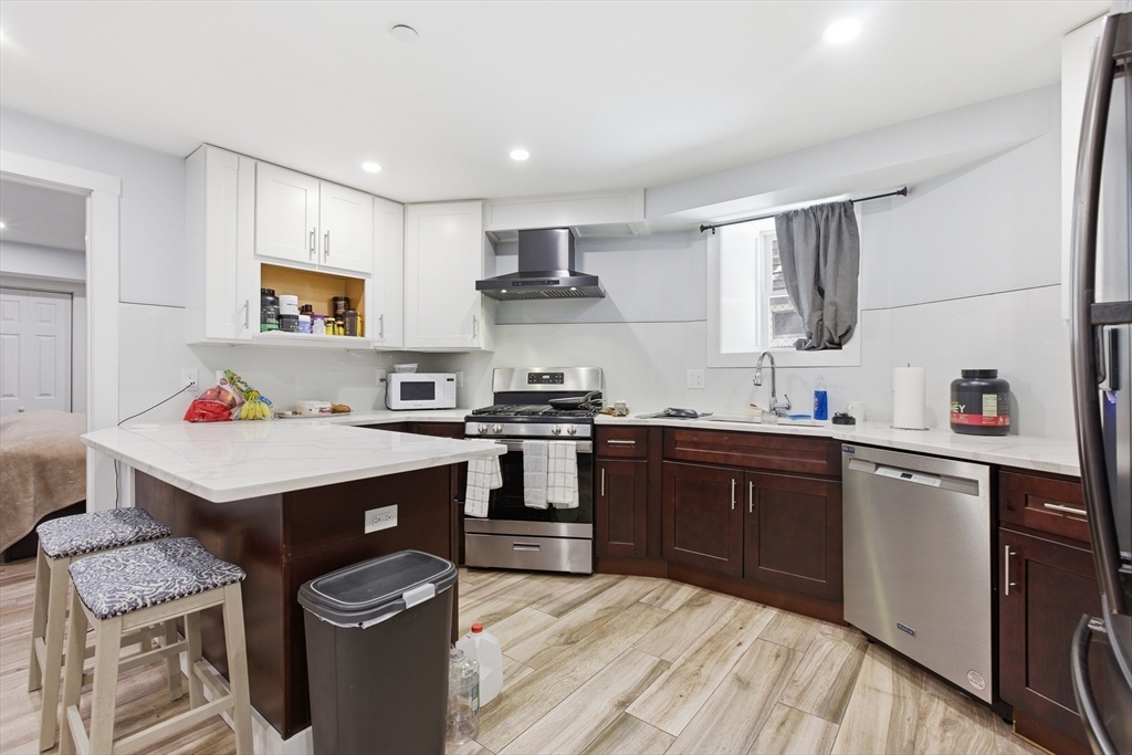 61 Shepton Street Boston, MA 02124 - Photo 14 of 41 a kitchen with granite countertop a sink stove and cabinets