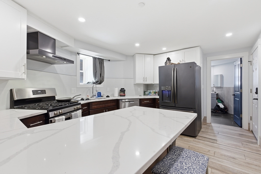 61 Shepton Street Boston, MA 02124 - Photo 24 of 41 a large kitchen with stainless steel appliances a refrigerator and a stove top oven