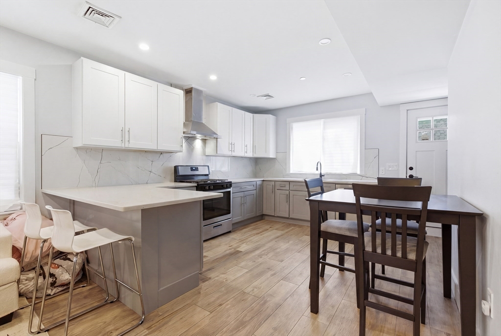 61 Shepton Street Boston, MA 02124 - Photo 8 of 41 a kitchen with a dining table chairs and white cabinets