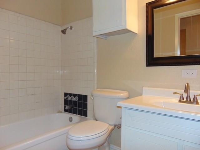1201 Rambler Road Arlington, TX 76014 - Photo 12 of 15 a bathroom with a toilet a sink a mirror and bathtub