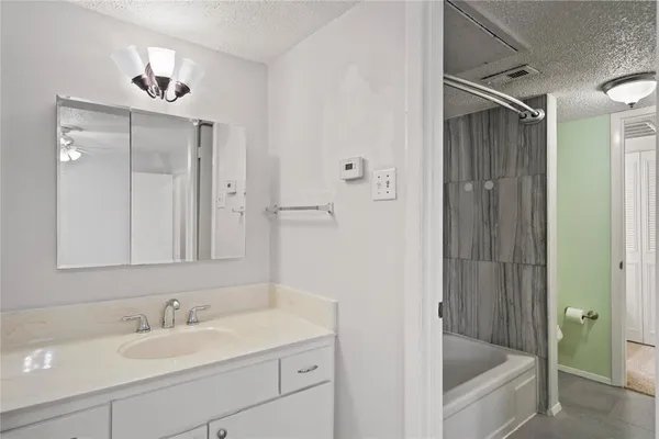 a bathroom with a tub sink and mirror