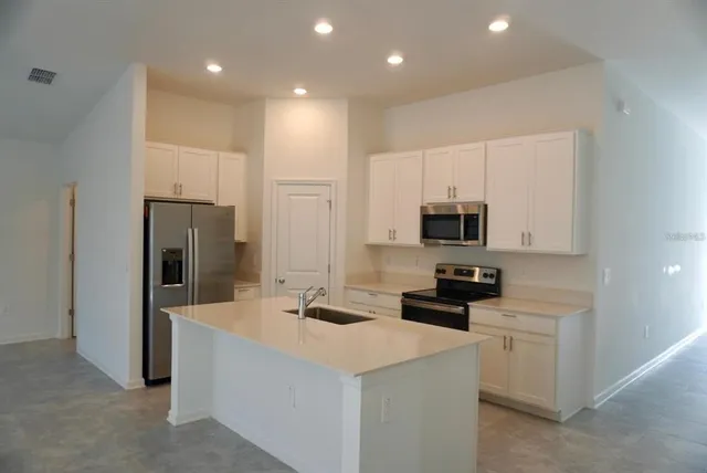 a kitchen that has a lot of cabinets and refrigerator