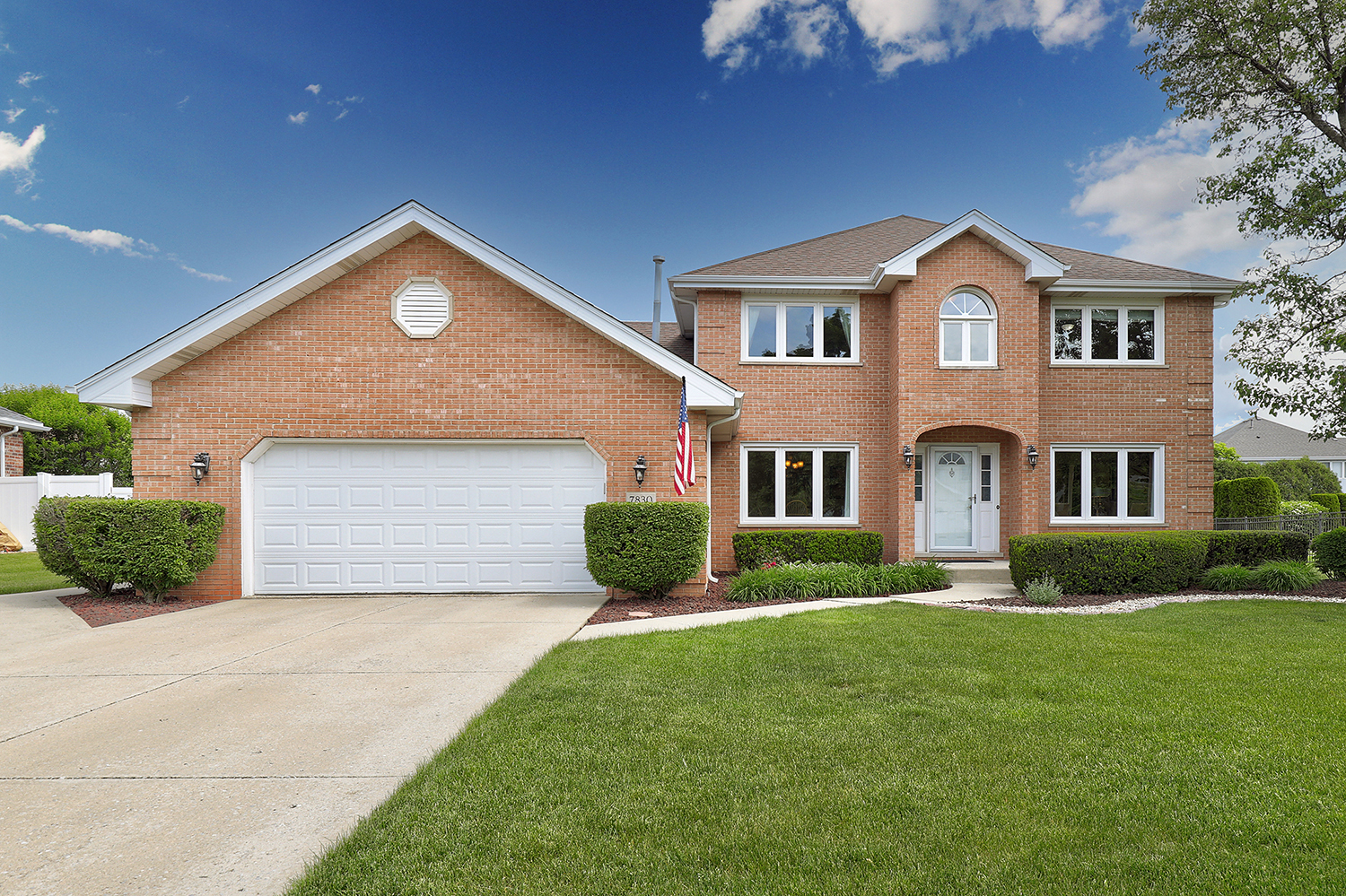 7830 Joliet Drive North Tinley Park, IL 60477 - Photo 1 of 19 a front view of a house with a yard and garage