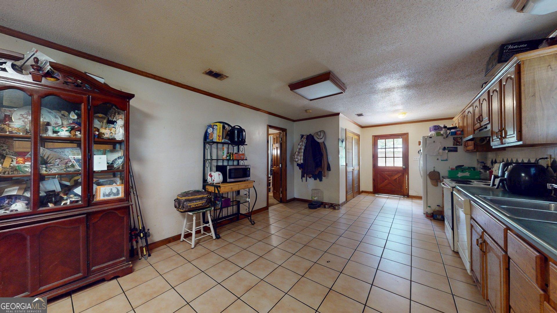 450 Bellevue Plantation Road Millen, GA 30442 - Photo 12 of 25 a kitchen with stainless steel appliances kitchen island granite countertop a refrigerator and a sink
