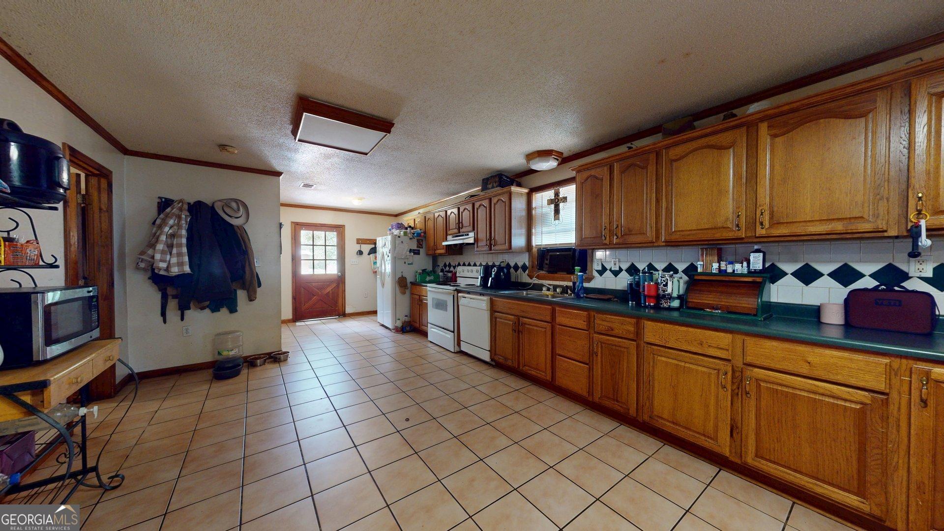 450 Bellevue Plantation Road Millen, GA 30442 - Photo 13 of 25 a kitchen with stainless steel appliances granite countertop a refrigerator and a stove top oven