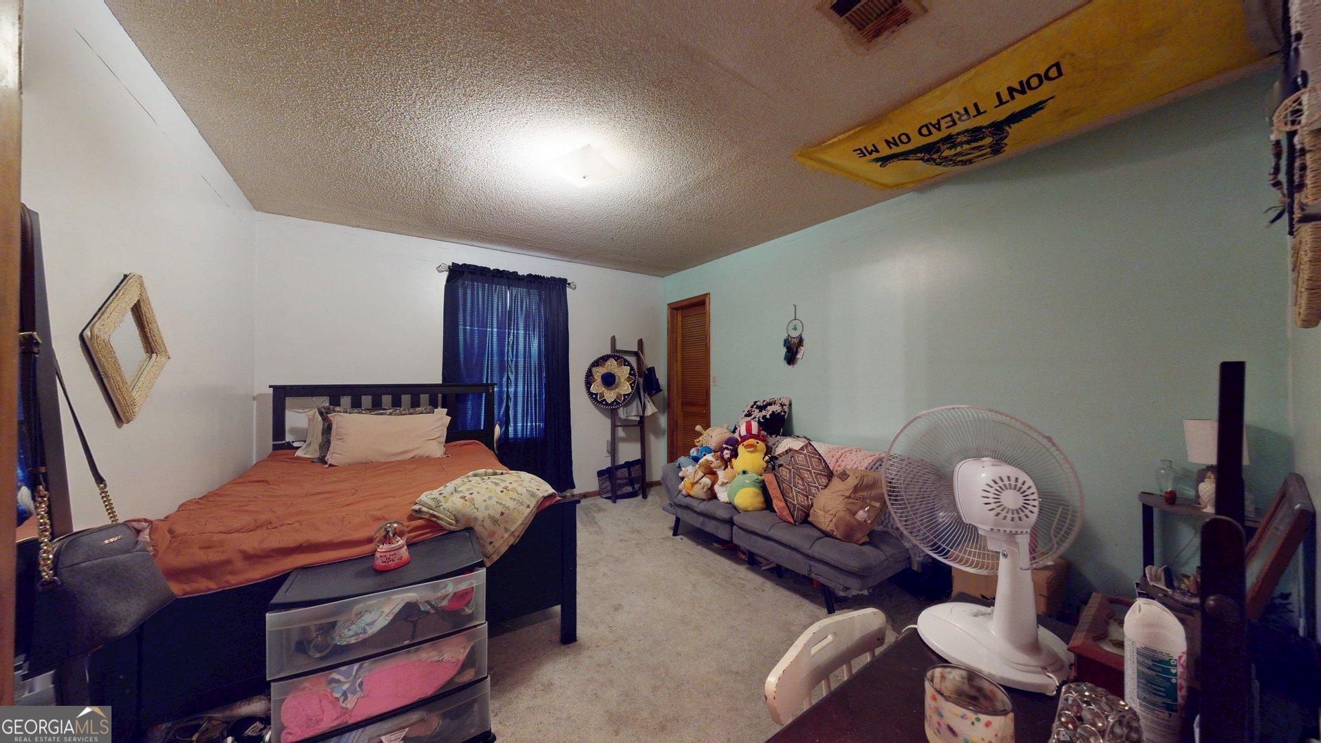 450 Bellevue Plantation Road Millen, GA 30442 - Photo 18 of 25 a bedroom with a bed a chandelier and dresser