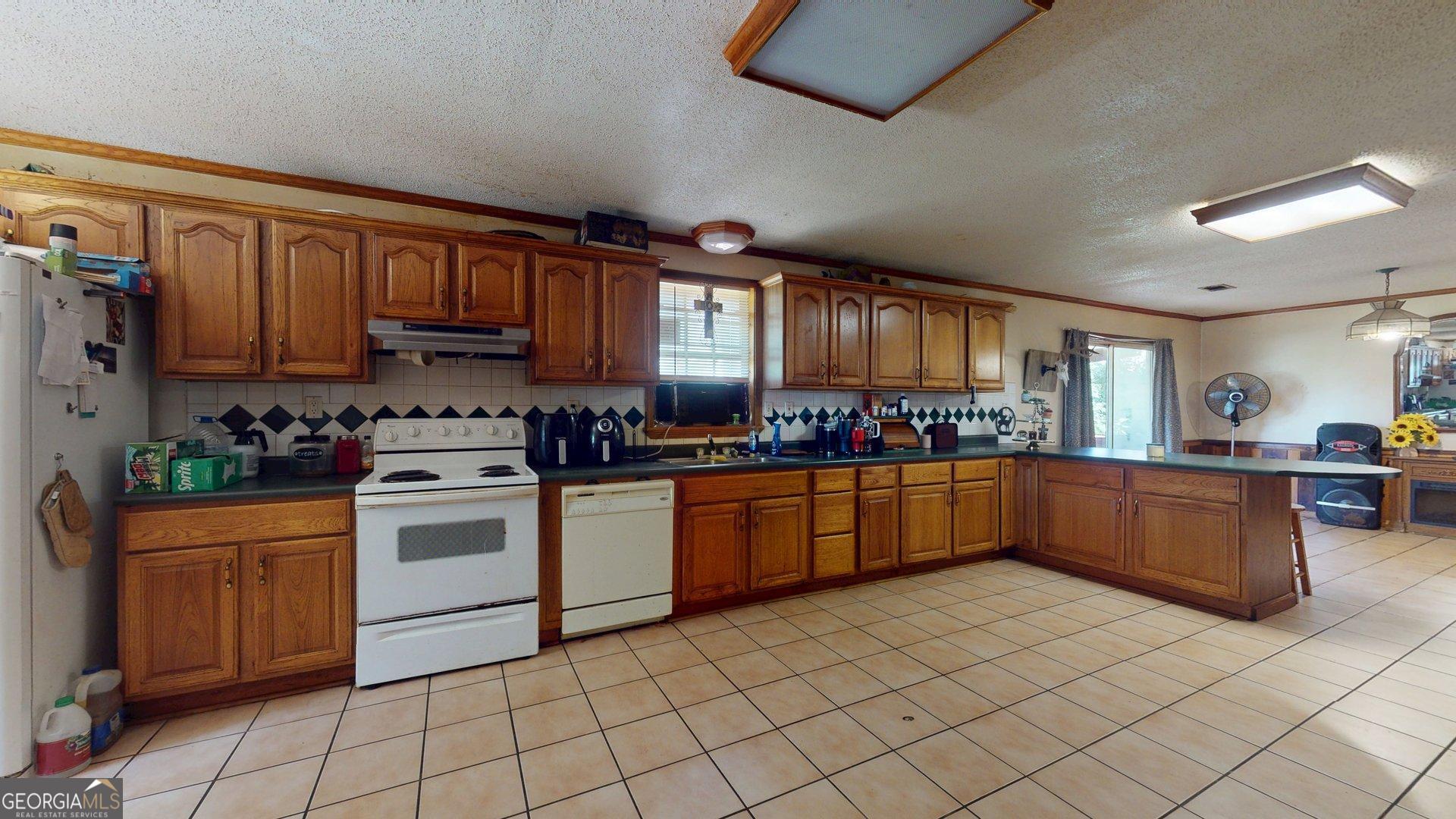 450 Bellevue Plantation Road Millen, GA 30442 - Photo 8 of 25 a kitchen with stainless steel appliances granite countertop a stove sink and cabinets