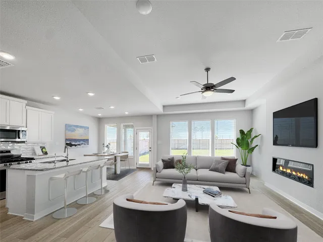 a living room with kitchen island furniture and a flat screen tv