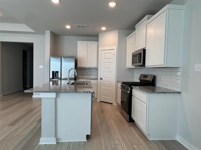 a kitchen with stainless steel appliances granite countertop a sink stove and refrigerator