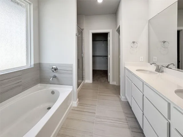 a spacious bathroom with a bathtub and a sink