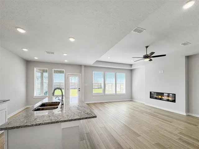 a view of a kitchen with granite countertop a stove and a wooden floor