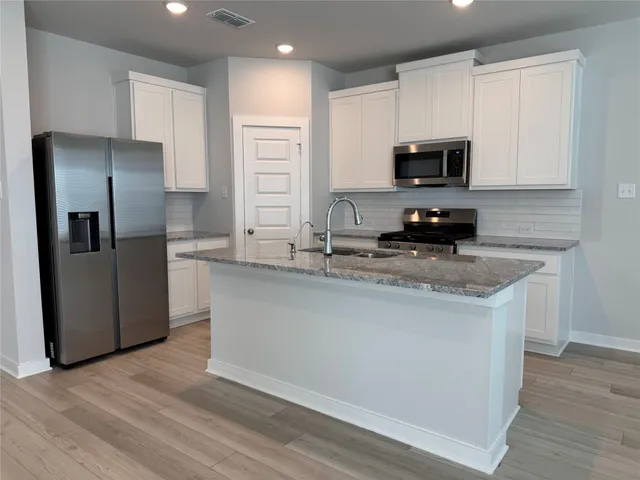 a kitchen with stainless steel appliances a microwave a sink and refrigerator