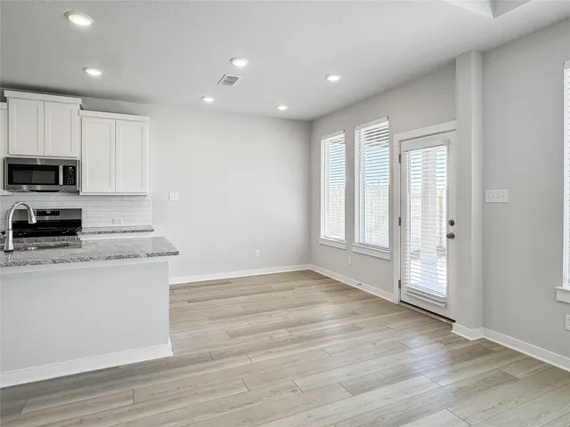 a view of kitchen with granite countertop cabinets and wooden floor