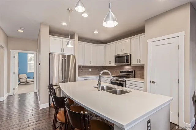 a kitchen with kitchen island a sink appliances and cabinets