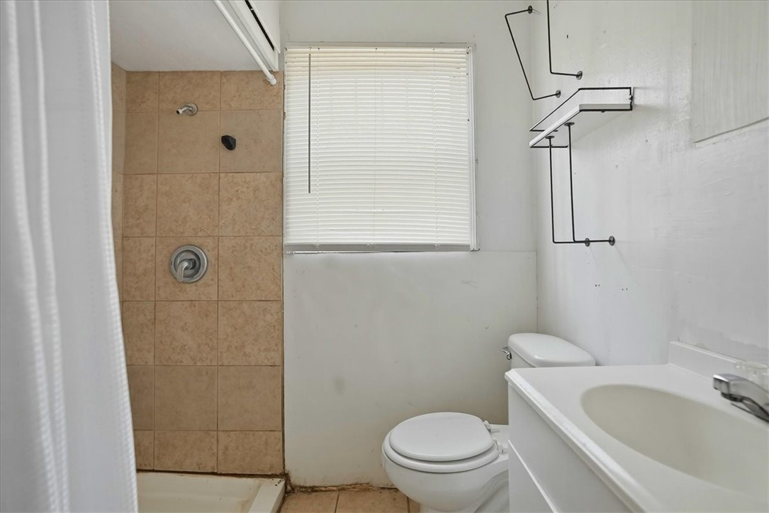 3633 Chestnut Street Corpus Christi, TX 78411 - Photo 16 of 22 a bathroom with a toilet a sink a shower and a mirror