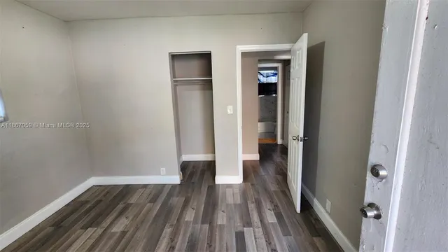 a view of a room with wooden floor and a ceiling fan
