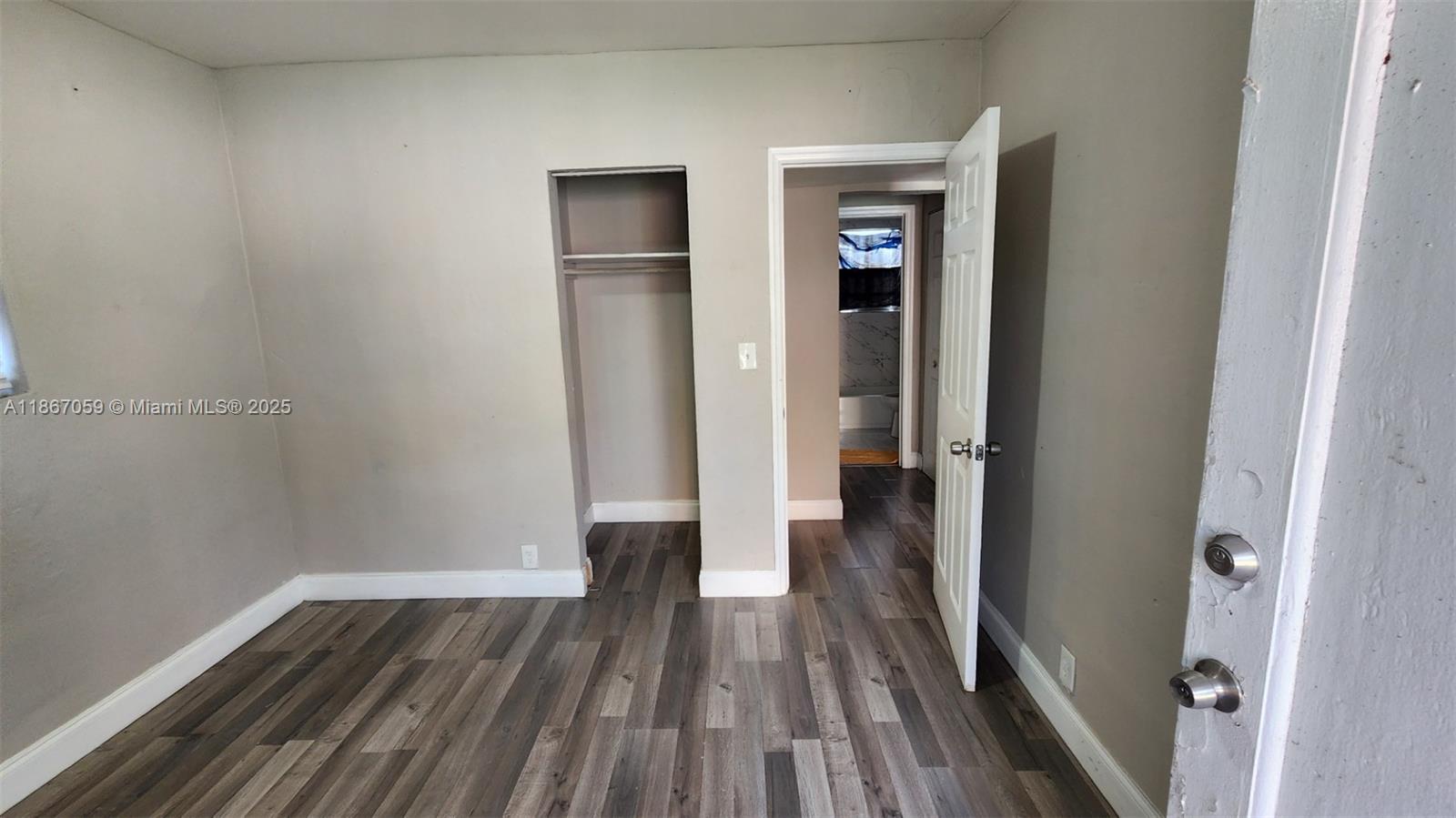 a view of a room with wooden floor and a ceiling fan