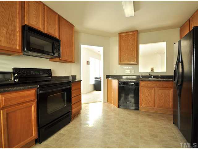 1421 Springshire Court Raleigh, NC 27610 - Photo 3 of 8 a kitchen with stainless steel appliances granite countertop a stove a sink and a microwave