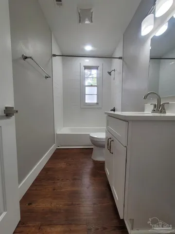 a bathroom with sink a toilet a shower and a window