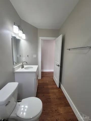 a bathroom with a sink a toilet a mirror and vanity