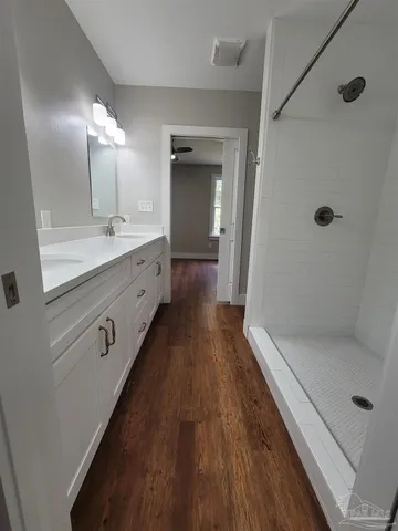 a bathroom with a double vanity sink and mirror with shower