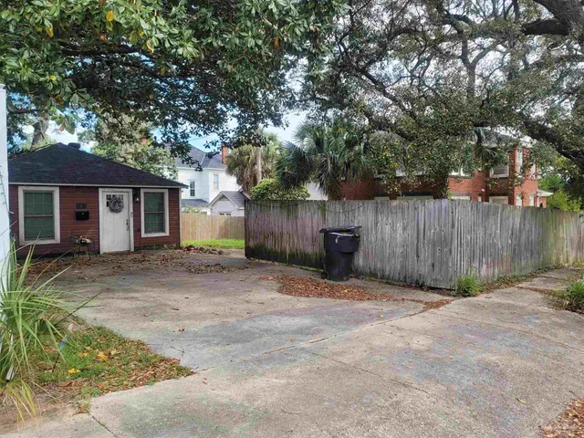 a backyard of a house with wooden fence and trees
