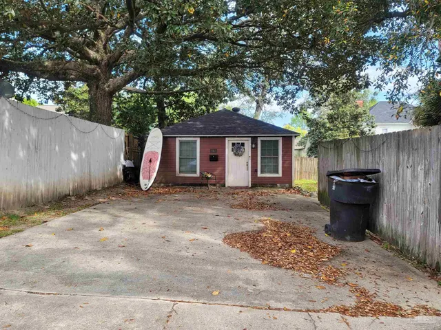 a view of a house with a barbeque and trees