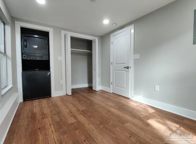 a view of empty room with wooden floor and closet