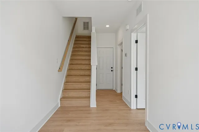 a view of a hallway with wooden floor and entryway
