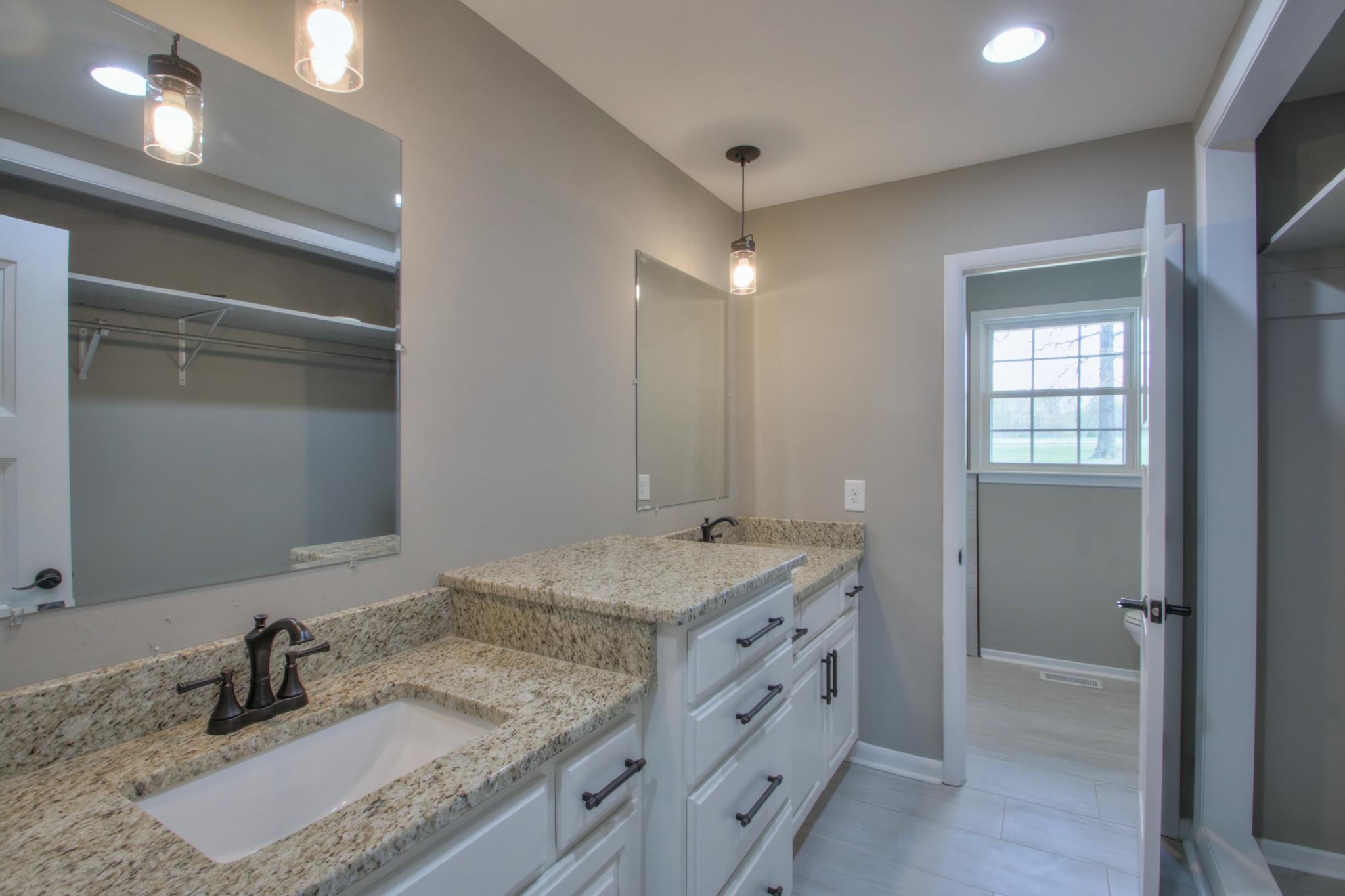 2964 Logan Road Greenbrier, TN 37073 - Photo 25 of 28 a bathroom with a granite countertop sink and a mirror