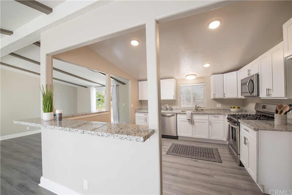 32785 Batson Lane Wildomar, CA 92595 - Photo 7 of 21 The remodeled kitchen is completely open and welcoming! There are granite counter tops and self closing cabinets and drawers. Nice view of your large lot from window above sink. There is room in the kitchen for a small dining room if you like that option. The room to the left has a slider door to the back patio and can double as a dining room or a separate family room.