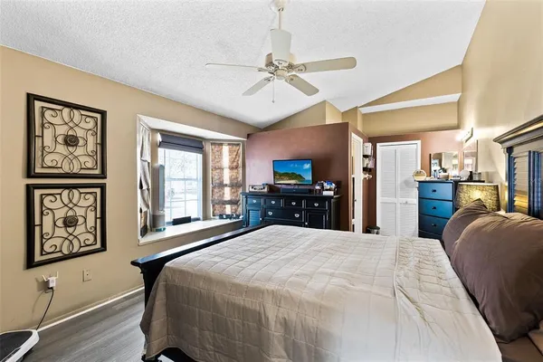 a large bedroom with a large bed and a flat tv screen