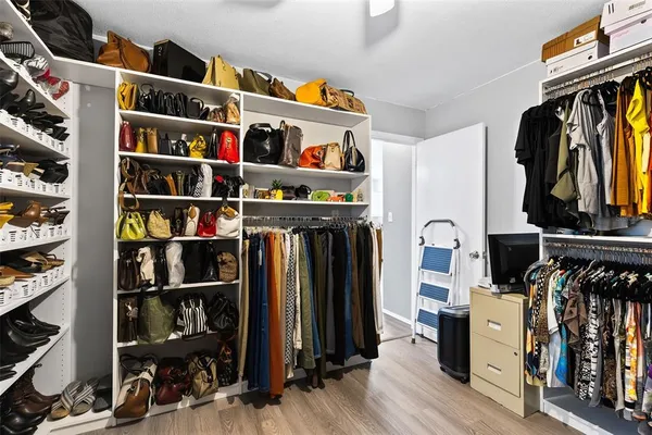 a view of walk in closet with clothes and shoes