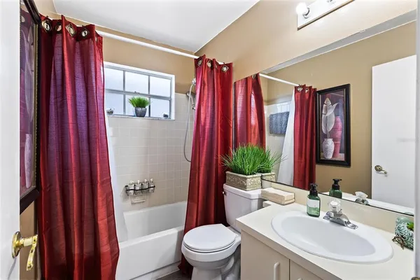 a bathroom with a toilet a sink and a shower curtain