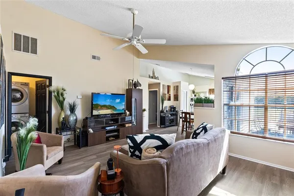 a living room with furniture a large window and a flat screen tv