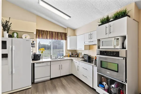 a kitchen with white cabinets and white appliances