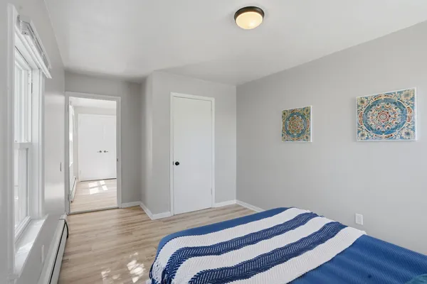 a bedroom with a bed and a painting on the wall