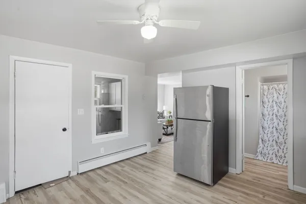 a view of kitchen with refrigerator cabinets and wooden floor