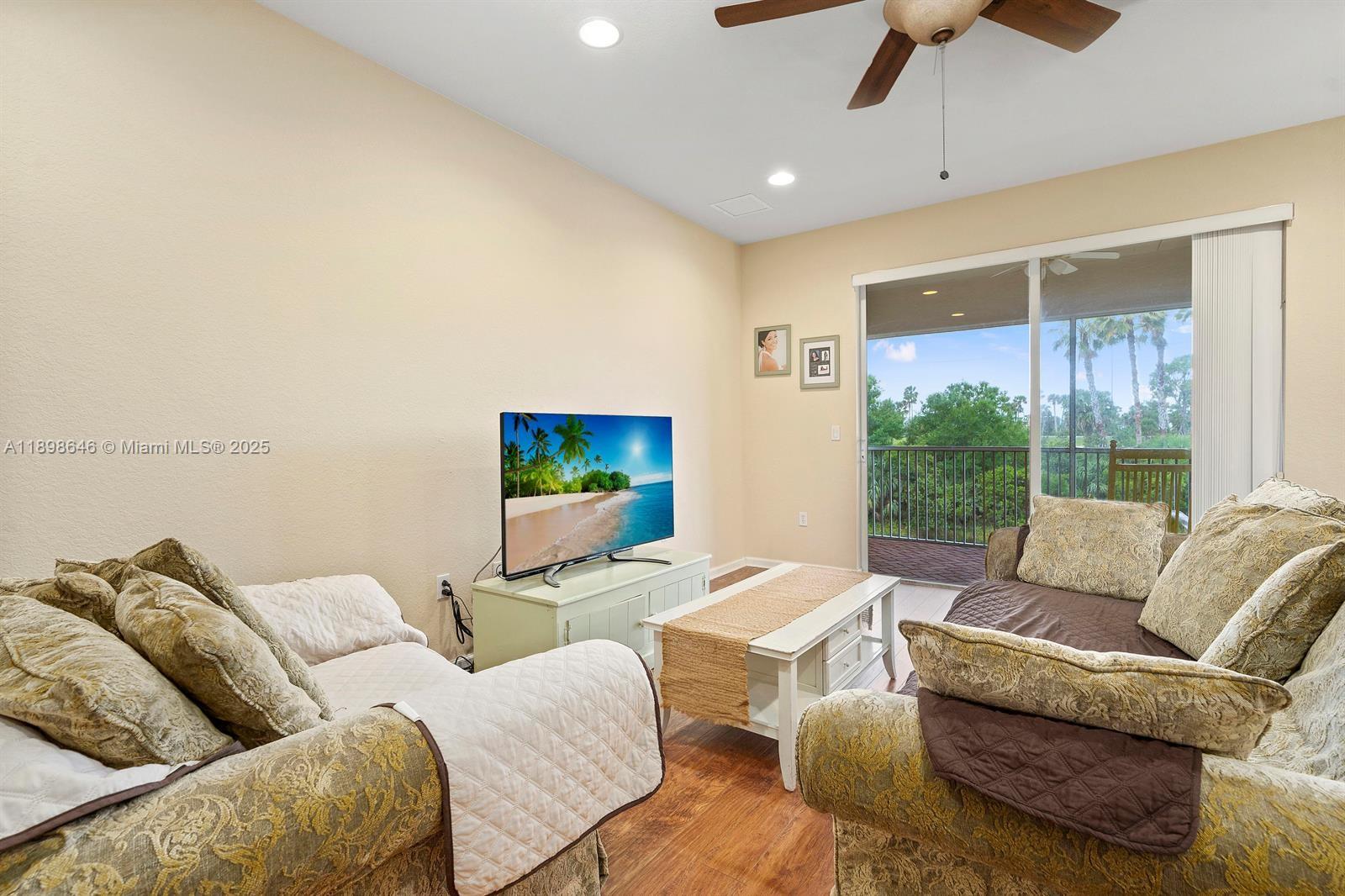 7550 Southwest Herrington Lane, Unit 7550 Stuart, FL 34997 - Photo 13 of 23 a living room with furniture and a flat screen tv