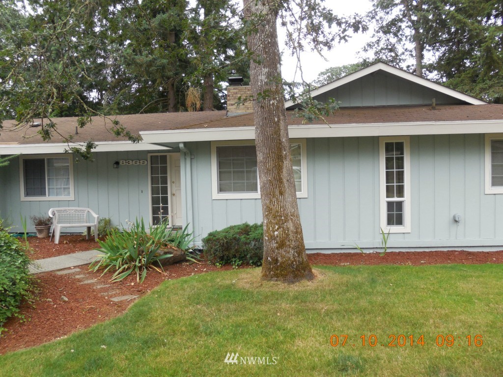 8327 Phillips Road Southwest Lakewood, WA 98498 - Photo 3 of 6 a view of a wooden house with a yard and large trees