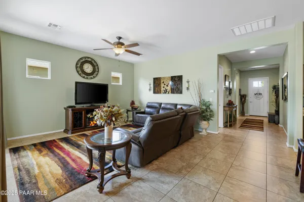 a living room with furniture a flat screen tv and a window