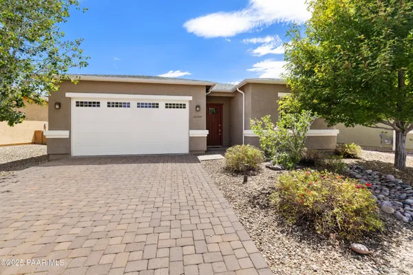 a front view of a house with a yard and a garage