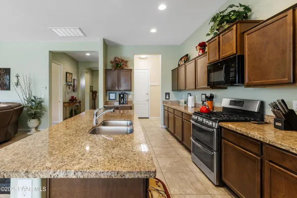 a kitchen with granite countertop a sink stove and cabinets