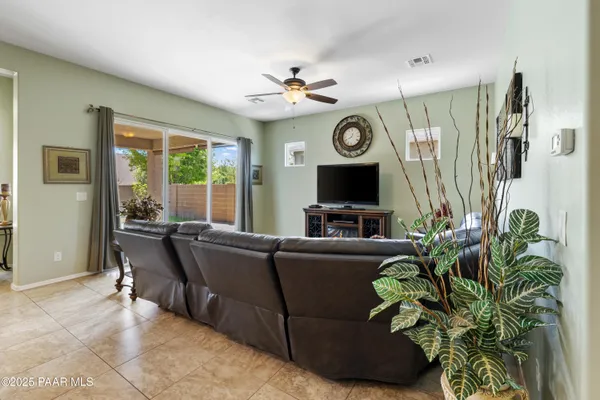 a living room with furniture a large window and a flat screen tv