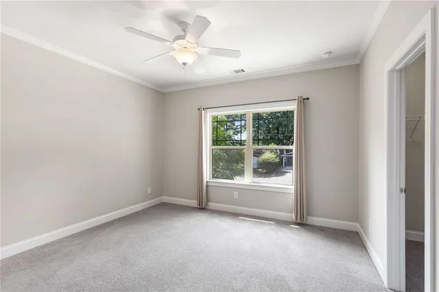 a view of an empty room and chandelier fan