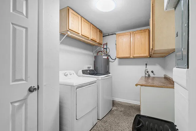 a utility room with cabinets washer and dryer