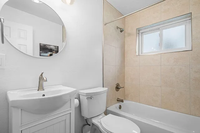 a bathroom with a toilet a sink a mirror and vanity